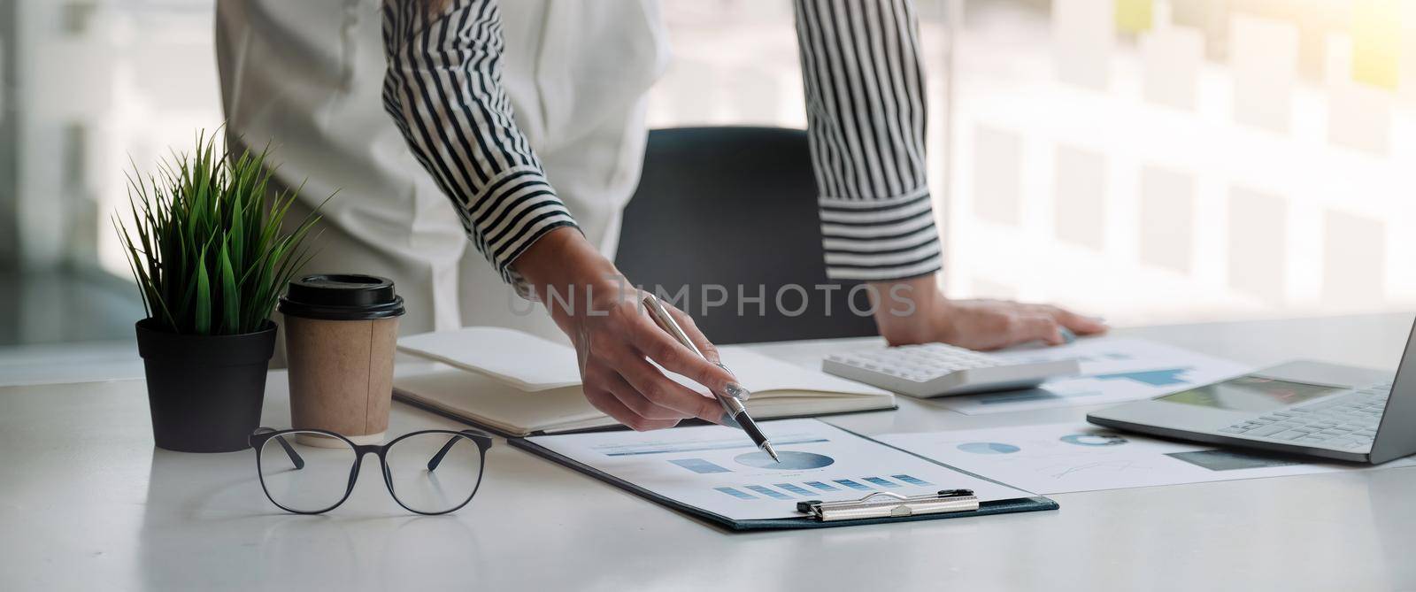 Financial Business woman analyze the graph of the company's performance to create profits and growth, Market research reports and income statistics, Financial and Accounting concept.