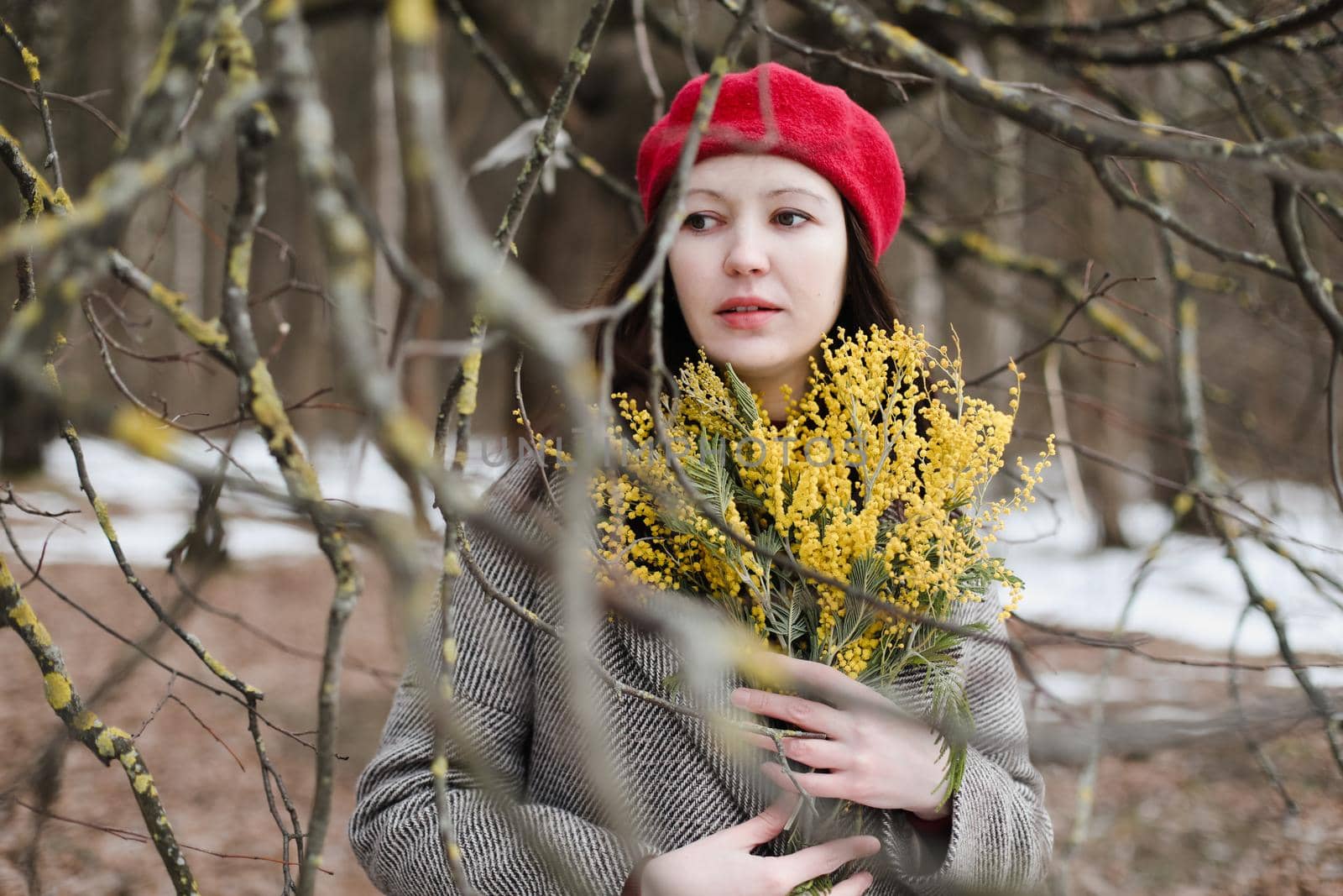 beautiful portrait of a young woman with mimosa flowers outdoors