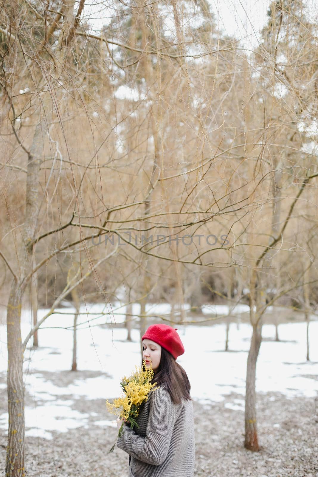 beautiful portrait of a young woman with mimosa flowers outdoors