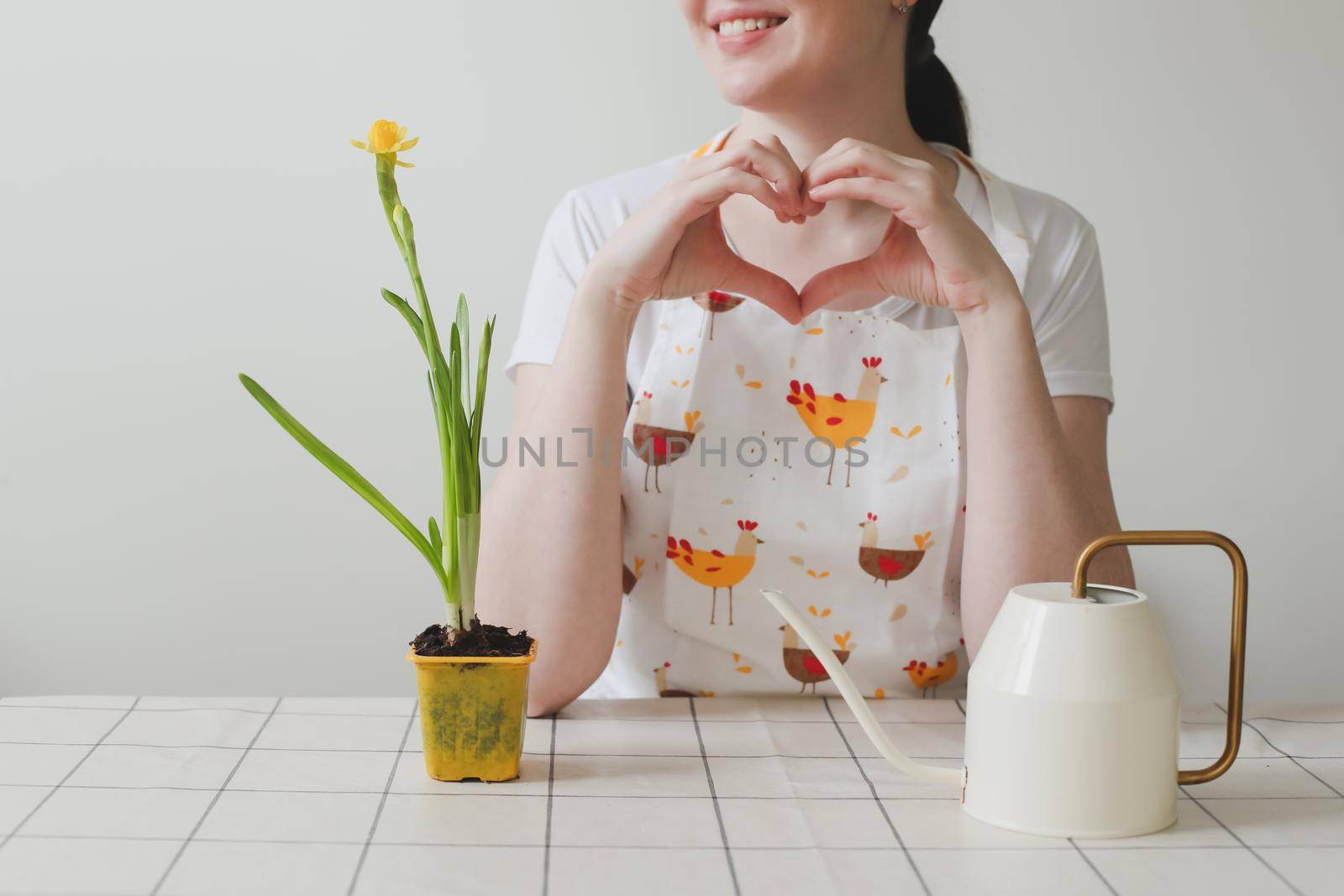 lovely housewife woman in apron with flower in pot. Gardening, holidays, Spring and Easter concept