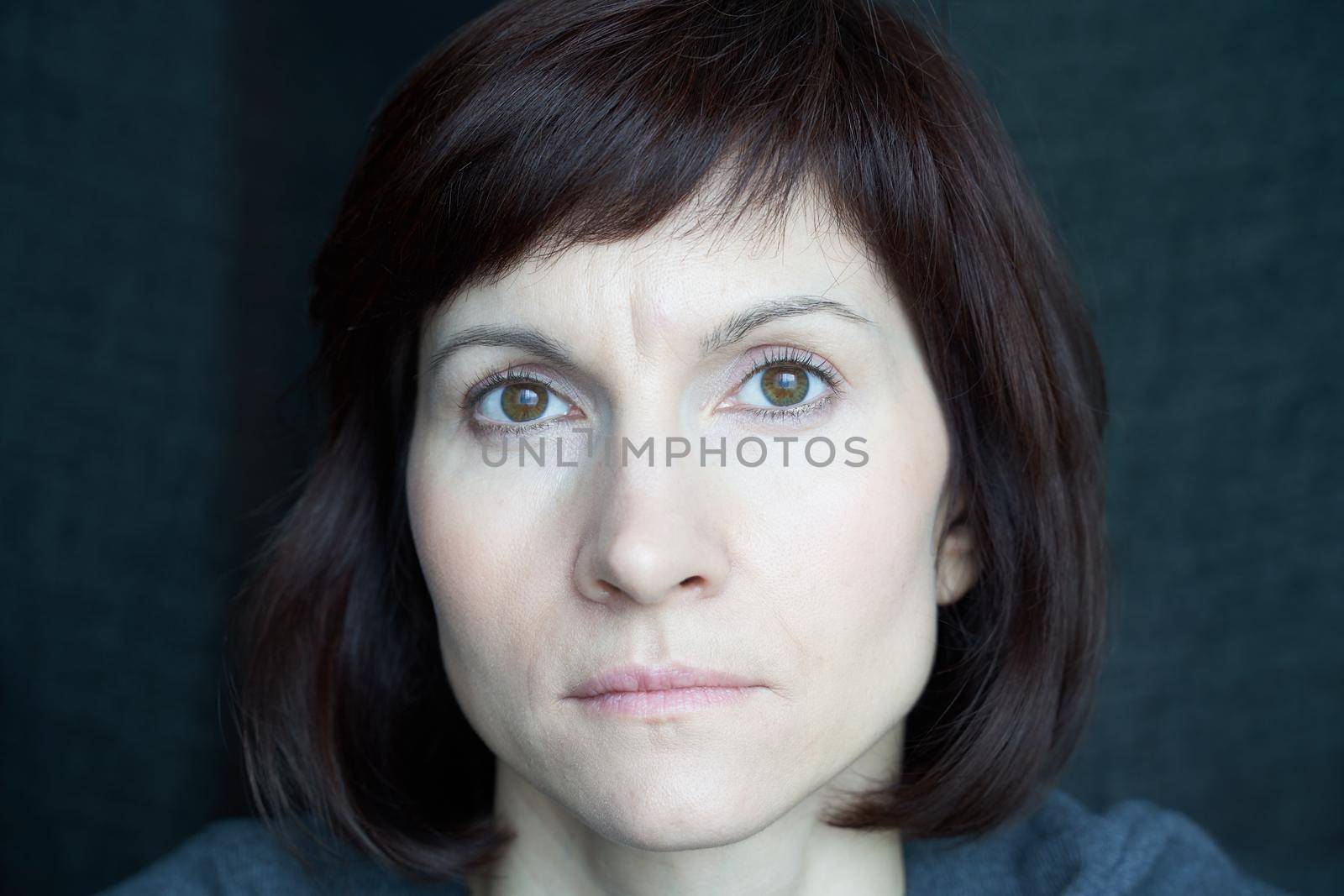 Portrait of mature woman in distress, close-up. Agitated tensed face. Look at camera by NataBene