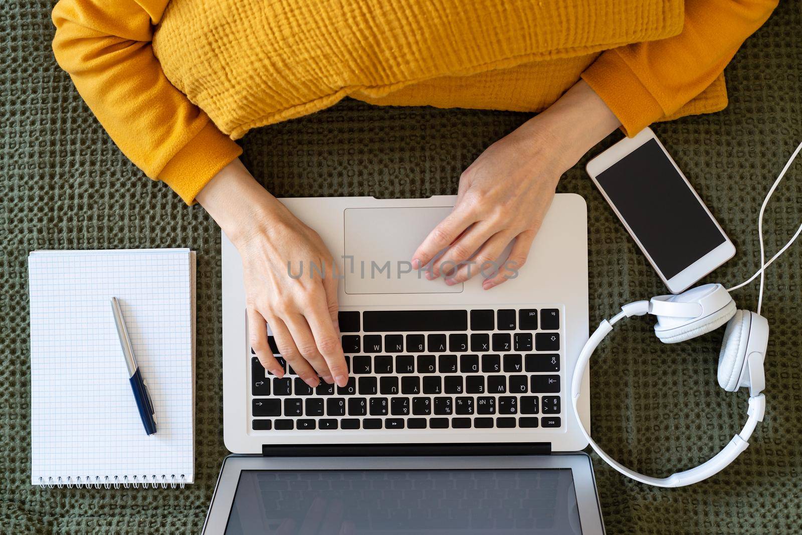 Online shopping, online learning, top view work at home. Distance education. Woman writing to blog on laptop laying on bed. Freelancer, digital nomad concept