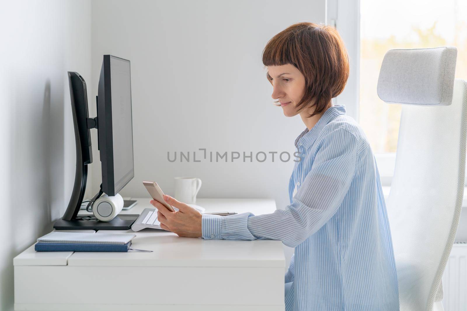 Woman looking at mobile phone, reading SMS with code and password to pay by NataBene