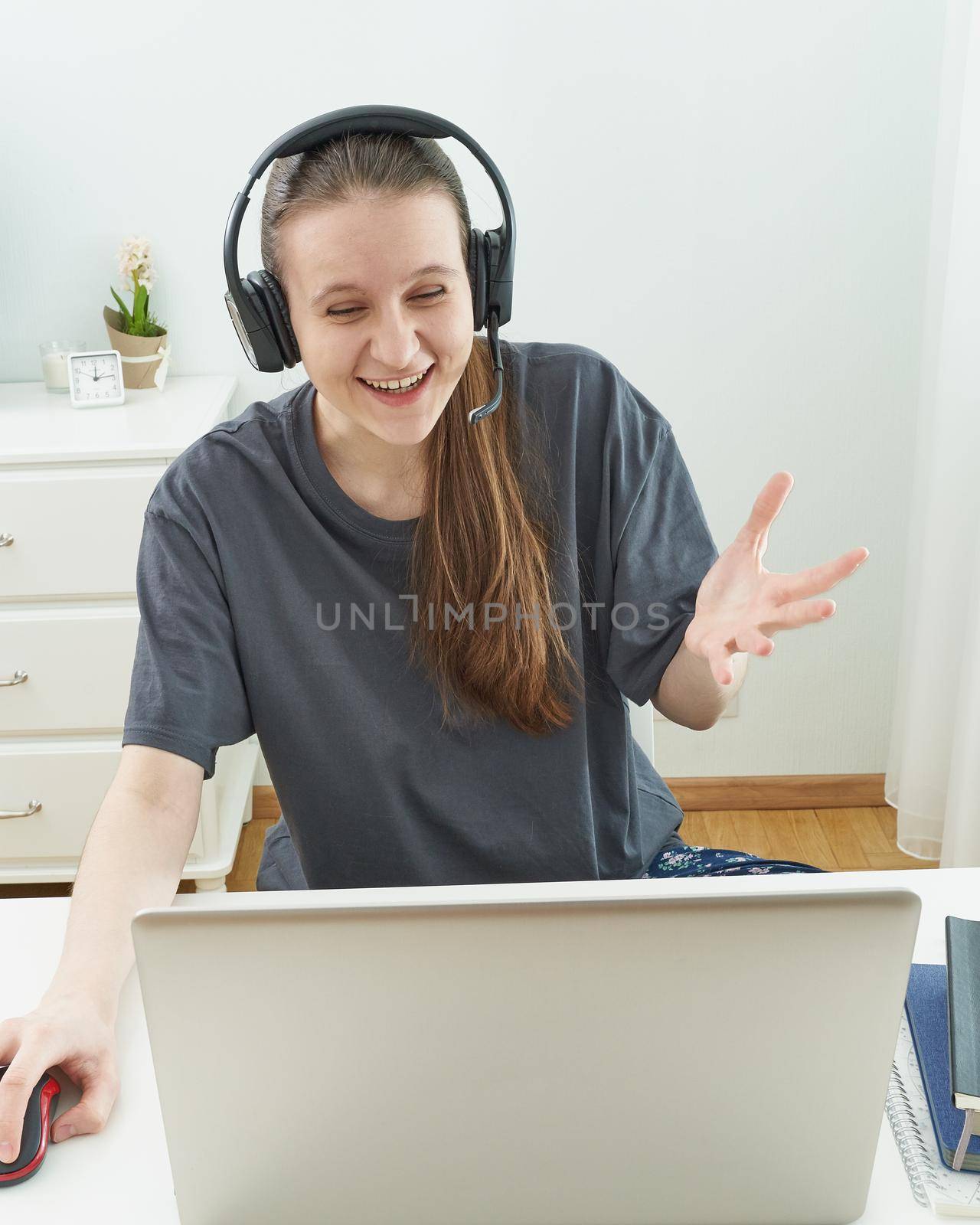 Girl with headphones looks at information on computer with surprise. Interesting moment in game. Quarantine, self-isolation, sociophobia.