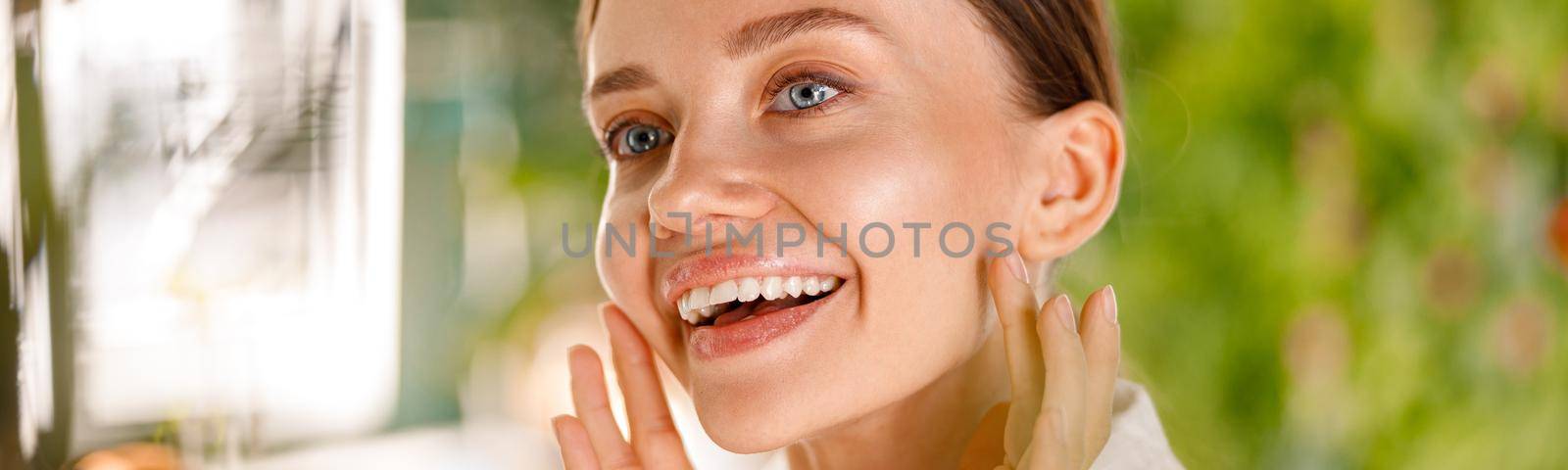 Closeup portrait of gorgeous young woman with smooth skin smiling while having beauty routine in the bathroom. Spa and wellness concept