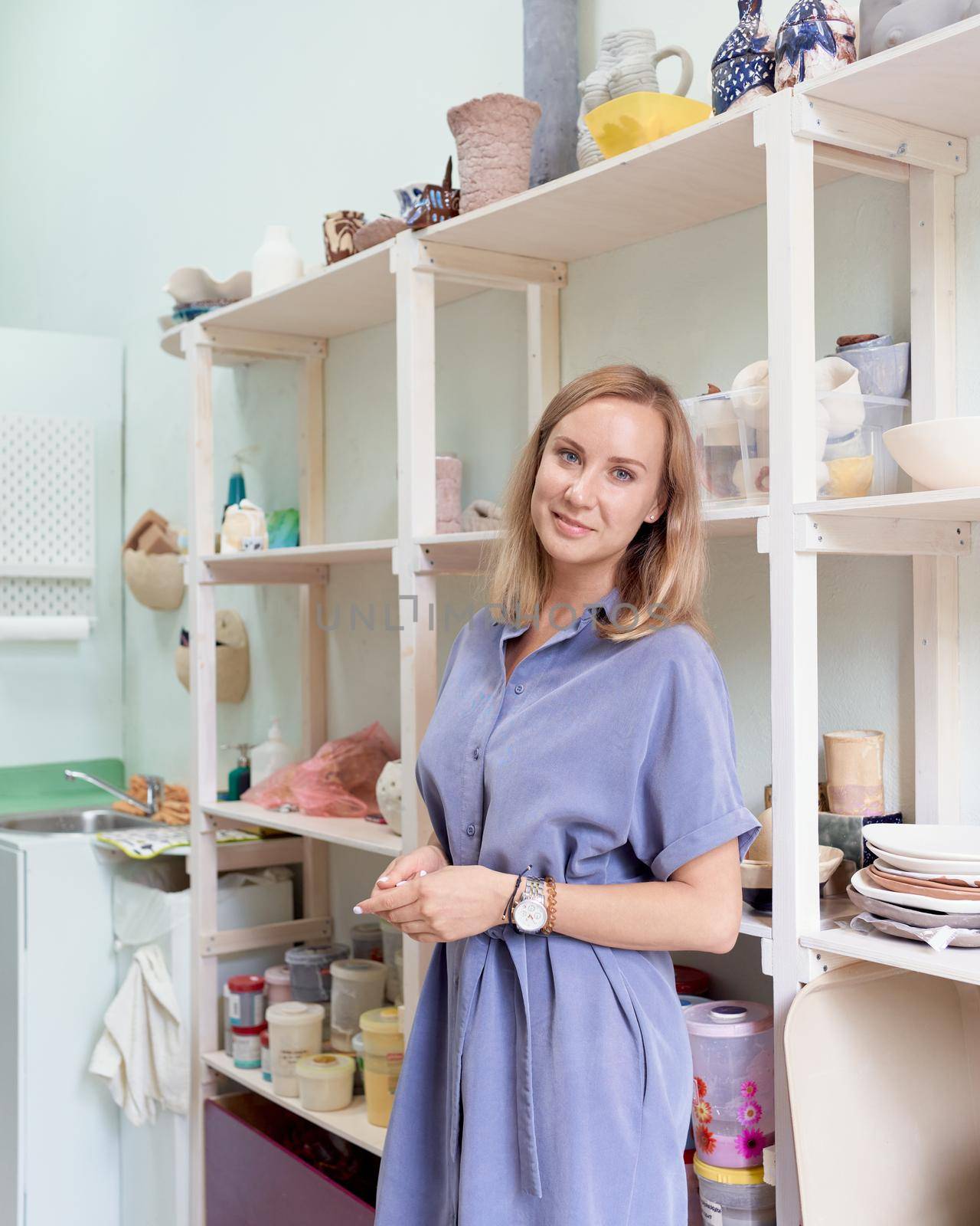 Business woman in pottery studio where she makes pottery. Hobby or small business for creative females to earn extra money on skills