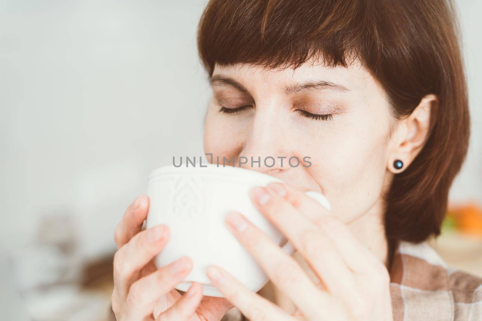 COVID-19 causes loss of smell. Woman sniffing smell of coffee from cup. Female inhaling aroma of fresh drink. SARS-CoV-2 pandemic.