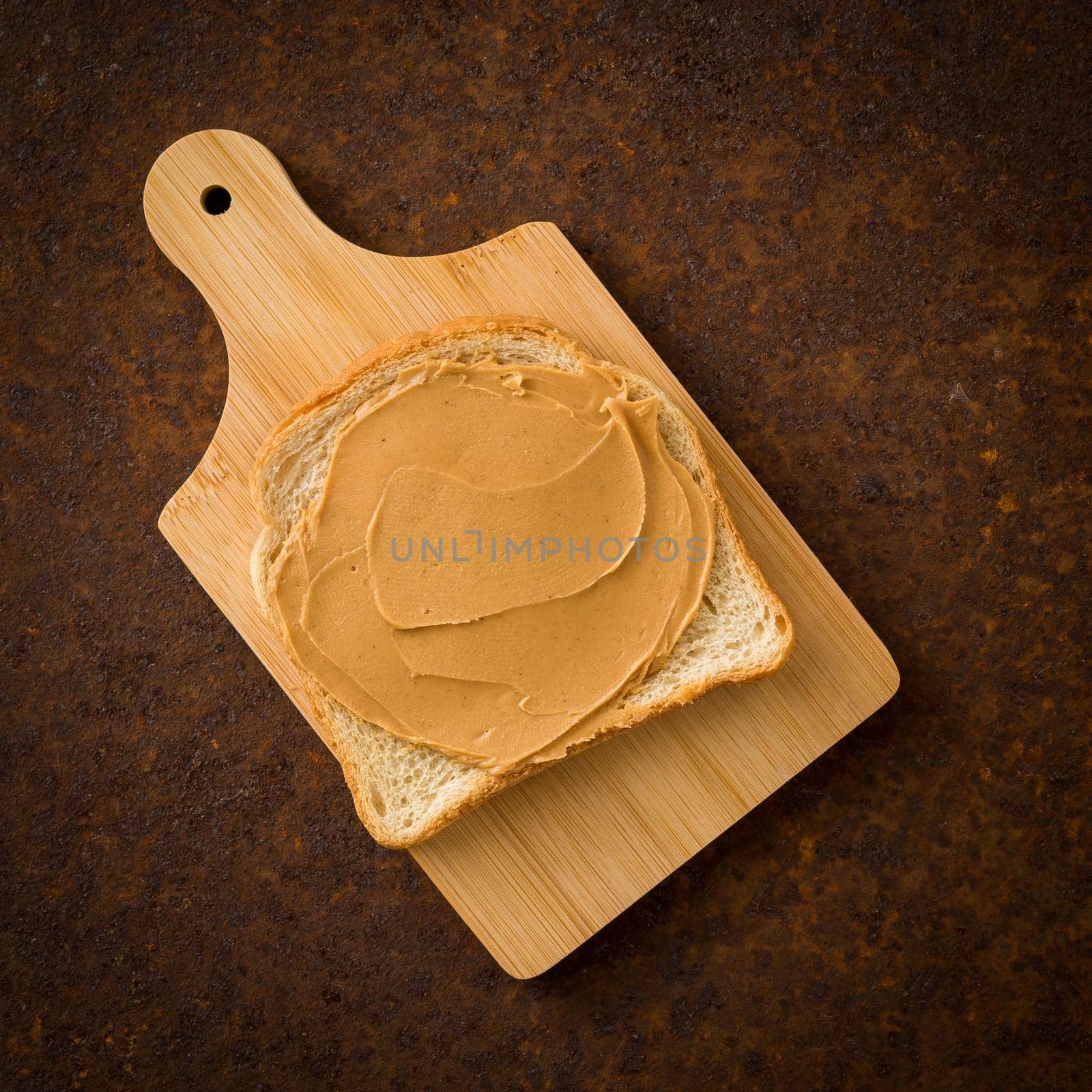 Peanut Butter on Toast. Old rusty metal dark background, top view.