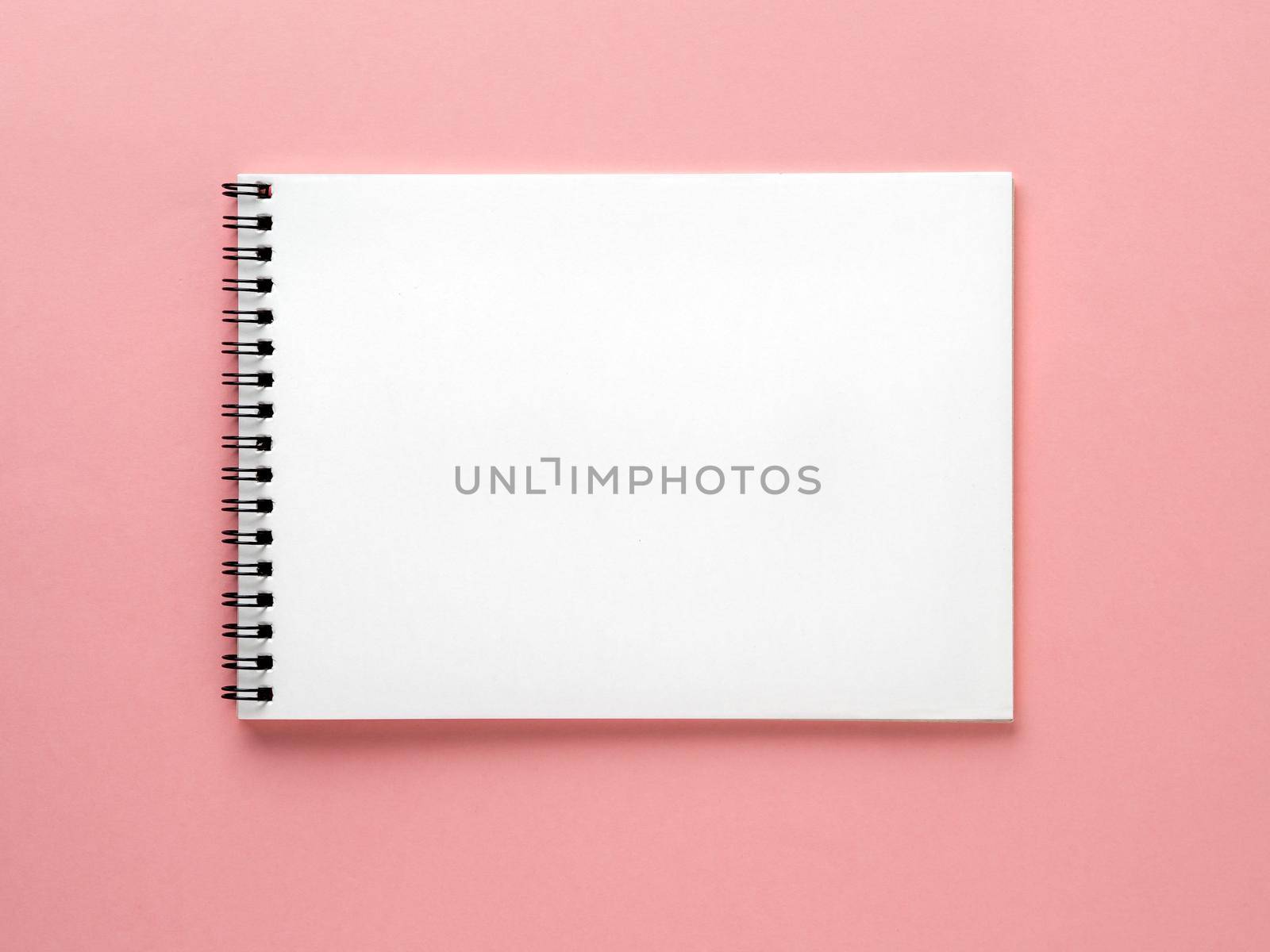 Blank notepad white page on pink desk, color background. Top view, flat lay. by NataBene