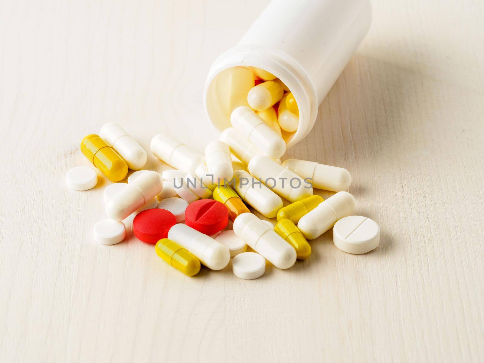 White open container with a medicament and pills on blue background