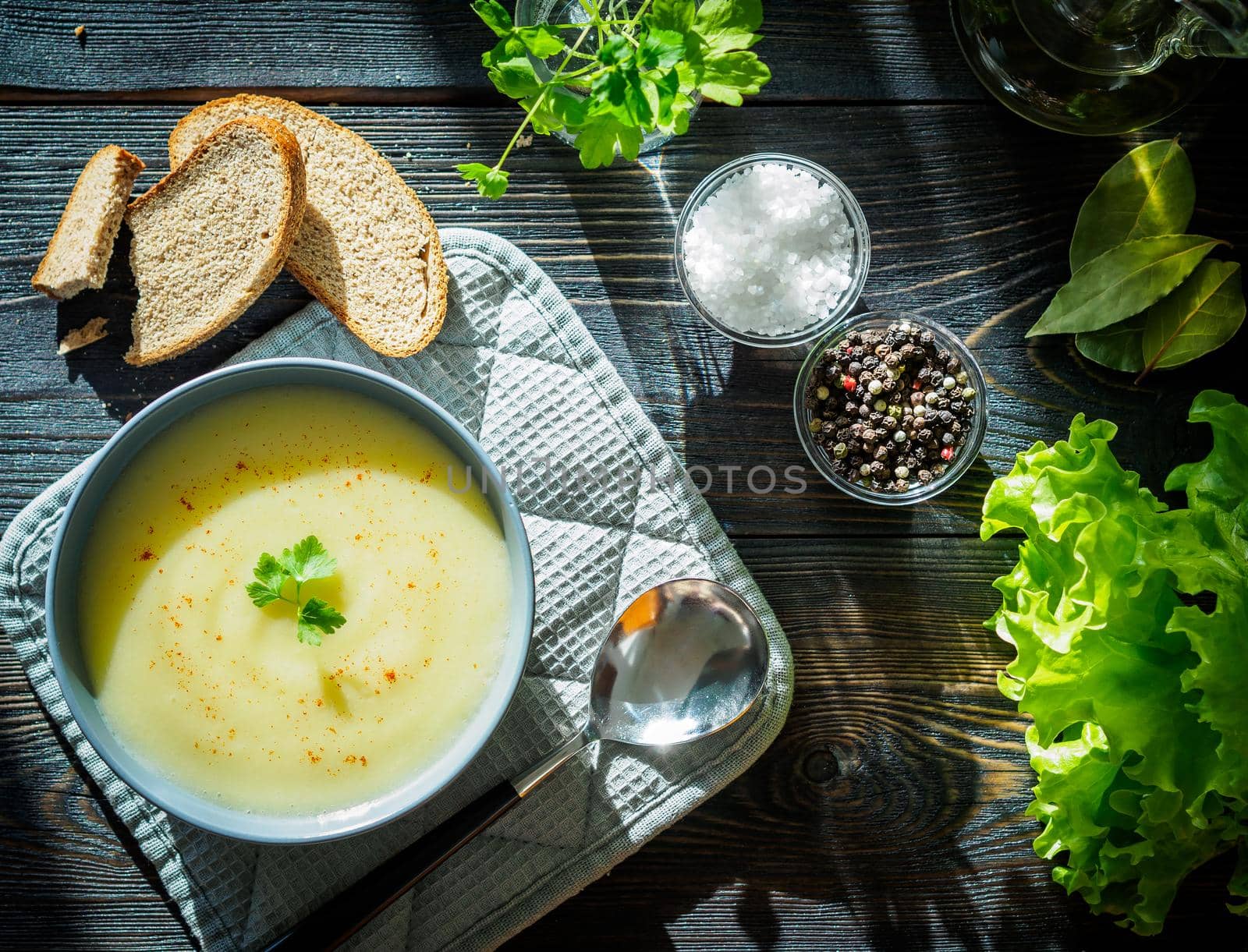 Dietary vegetarian cream soup puree, with potatoes and cauliflower, on a dark brown-blue wooden table, top view. by NataBene