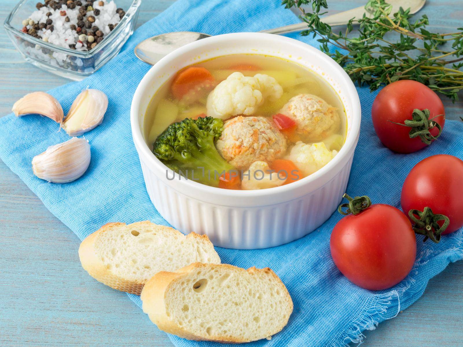 Delicious, thick Soup with Turkey meatballs and mixed vegetables - cauliflower, broccoli, carrots, potatoes, garlic, tomatoes. Close-up, side view