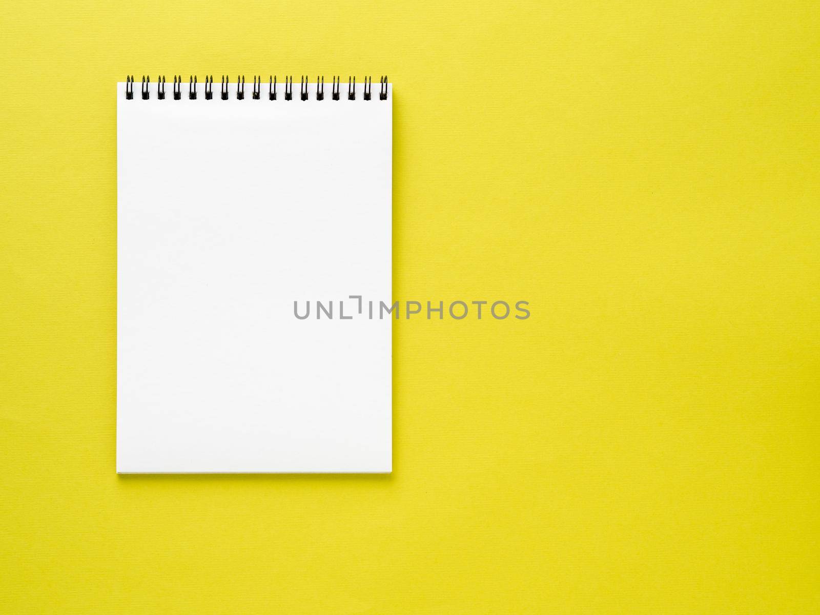 Blank notepad white page on yellow desk, color background. Top view, empty space for text. by NataBene