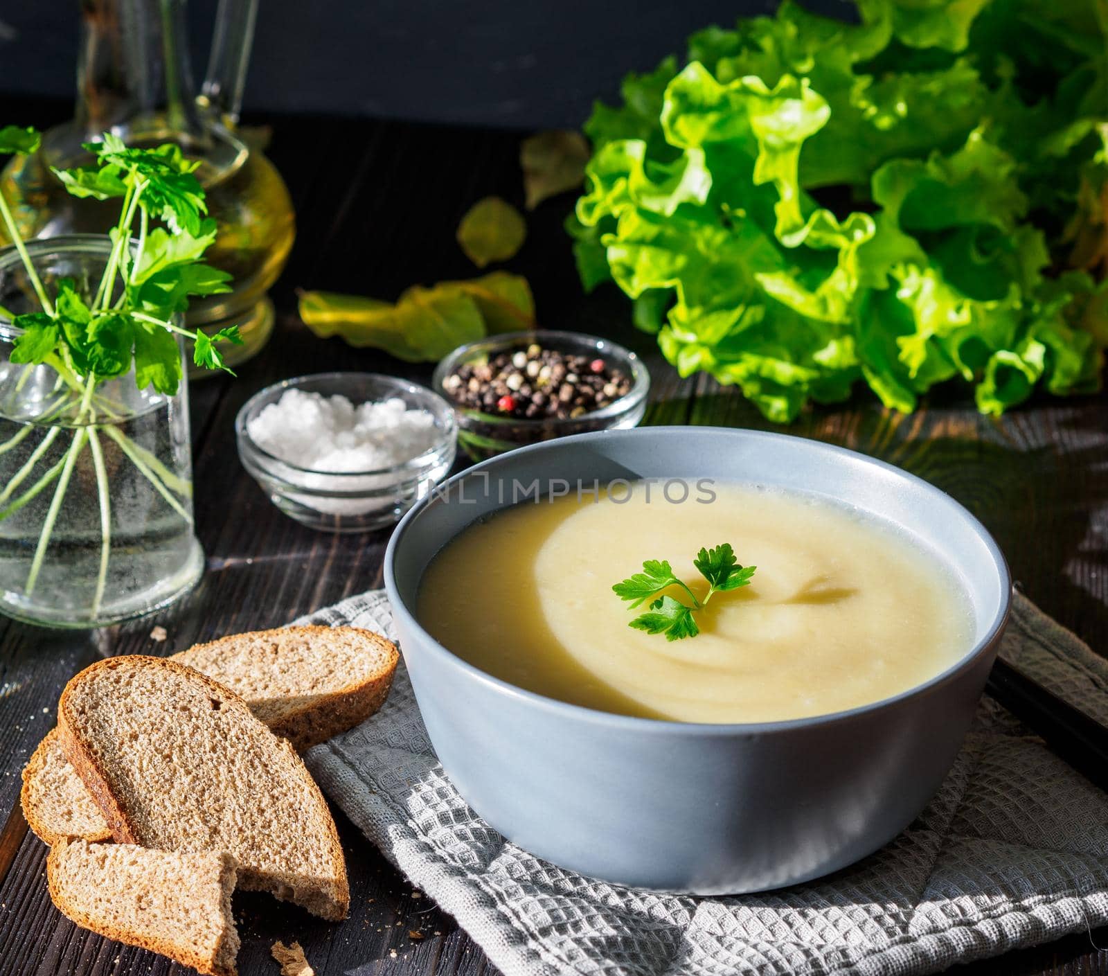 Dietary vegetarian cream soup puree, with potatoes and cauliflower, on a dark brown-blue wooden table, side view, close up by NataBene