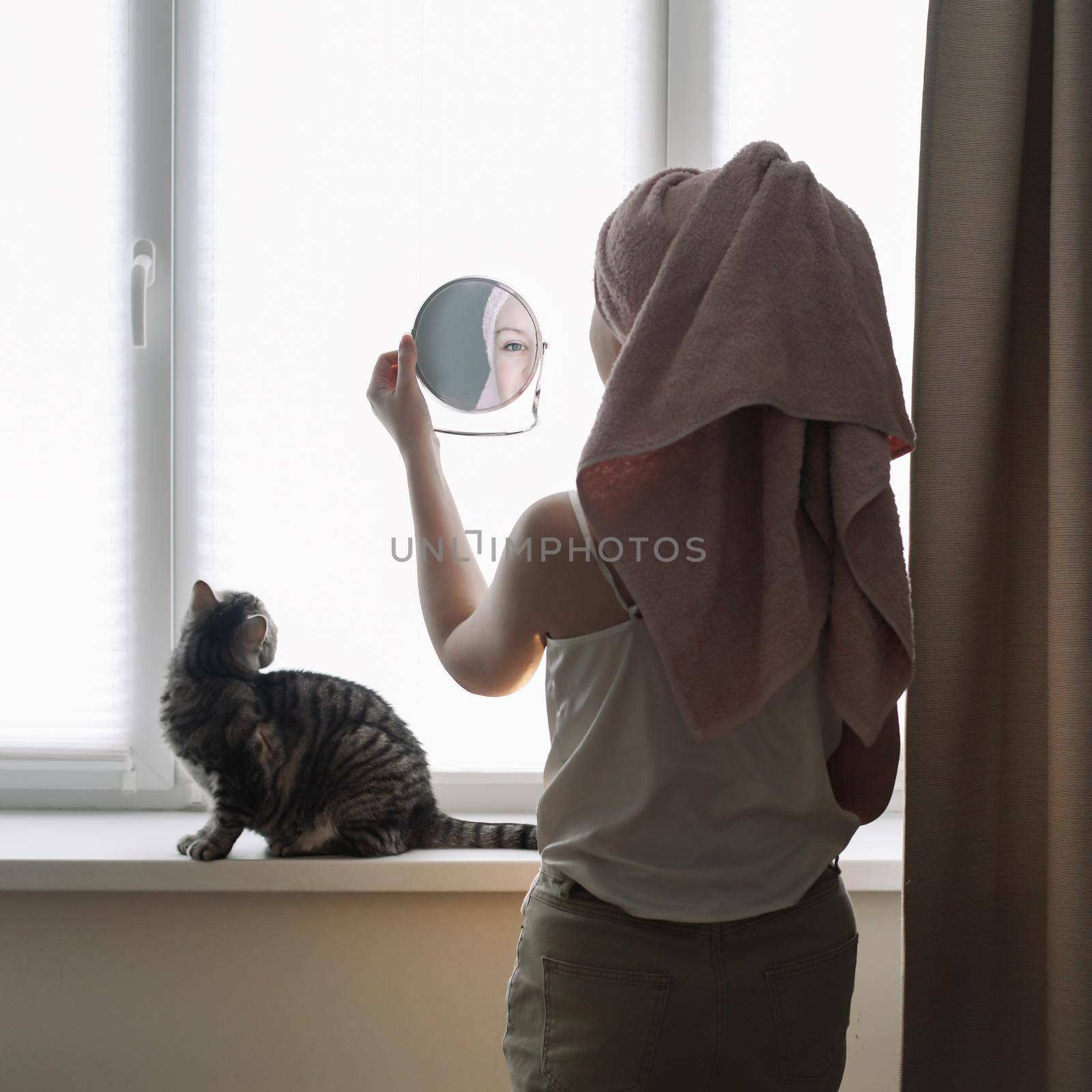 Young woman and her adorable cat at home. Lazy weekend at home with loved pet concept. Close up, copy space, interior background. Love, togetherness and pets indoors by paralisart