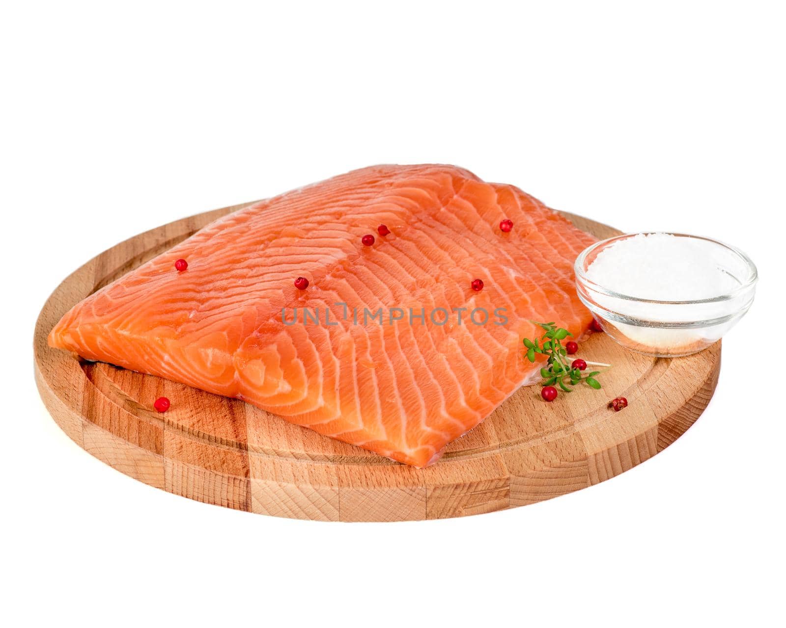 Fresh salmon fillet on wooden cutting board on white background, side view