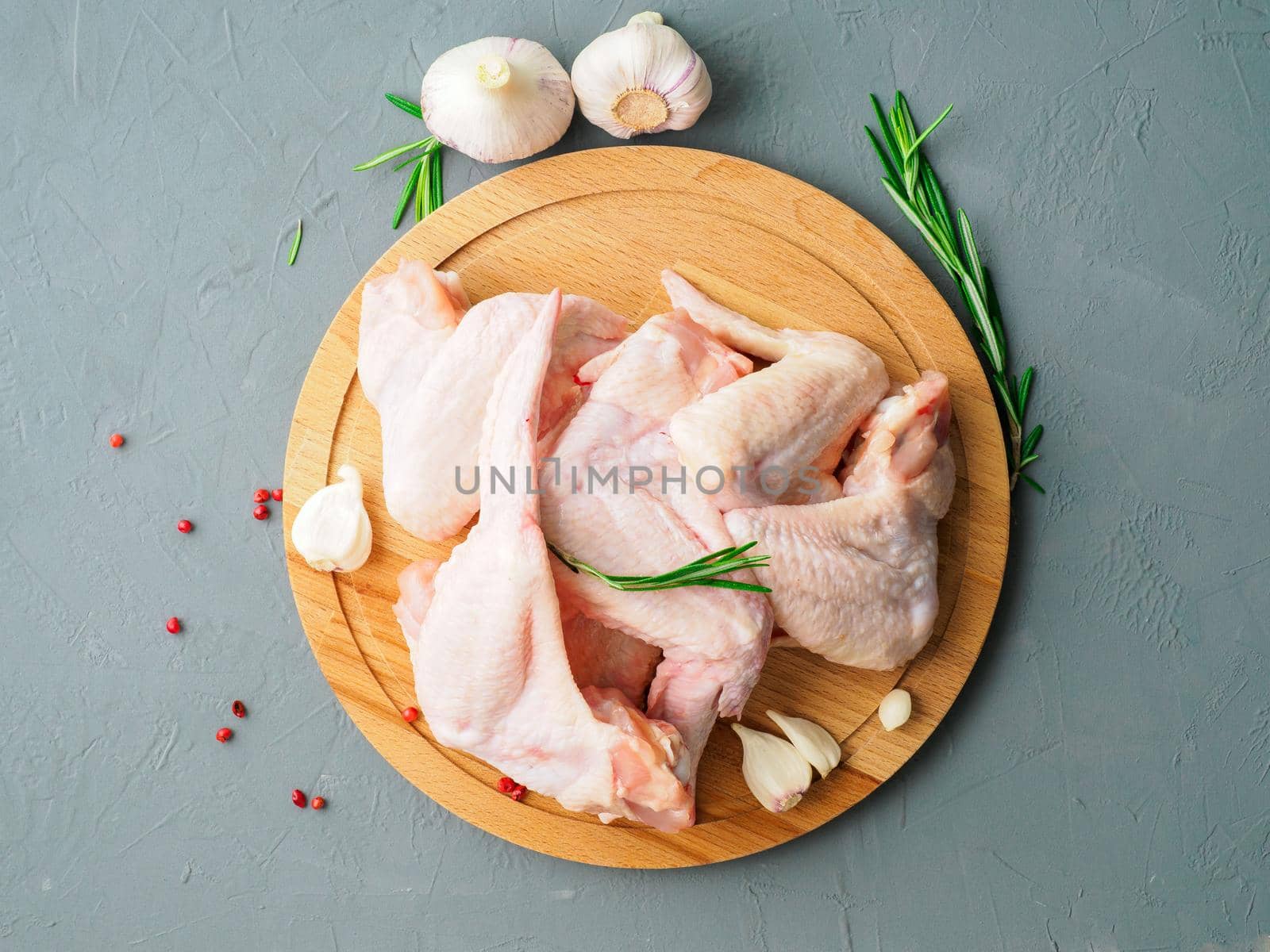 raw fresh chicken wings on wooden board, grey concrete background, top view by NataBene