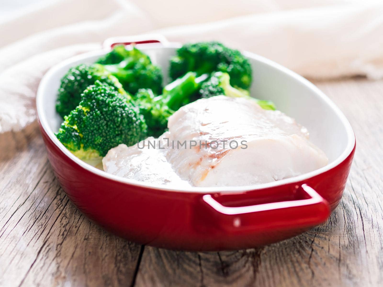 Fish cod baked in the oven with broccoli - healthy diet healthy food. Rustic wooden brown background, side view, selective focus.