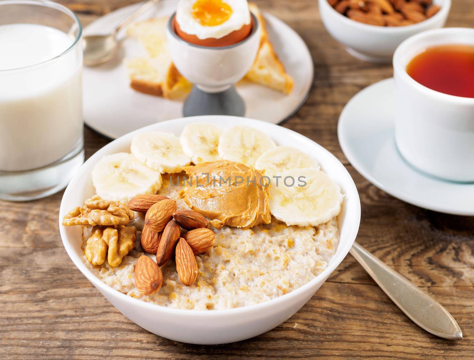 healthy breakfast - oatmeal with nuts, soft boiled eggs, selective focus, side view, close up