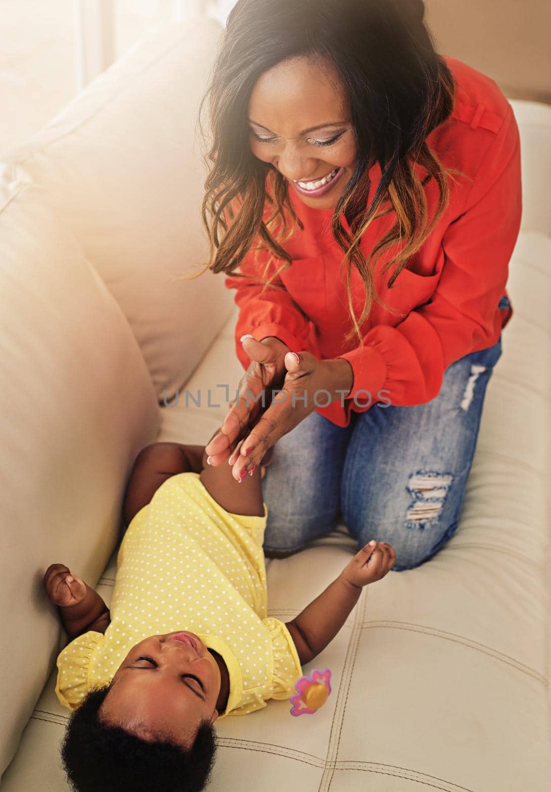 We have so much fun together. Shot of a mother playing with her baby girl at home. by YuriArcurs