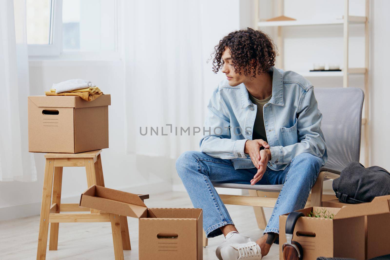 handsome guy cardboard boxes in the room unpacking interior. High quality photo