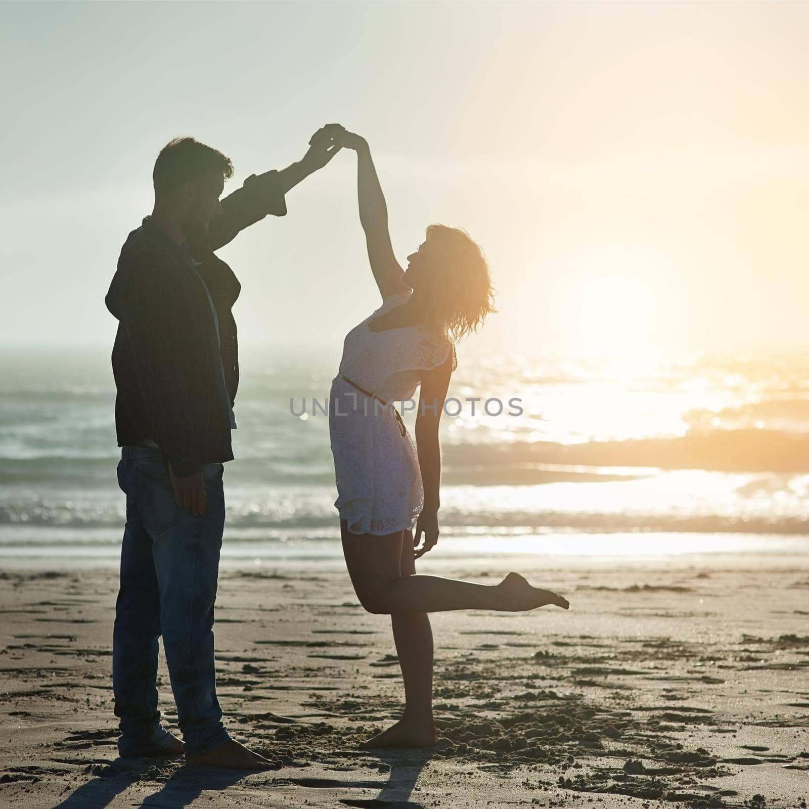 Your presence makes my heart dance. Shot of an affectionate young couple enjoying their time on the beach. by YuriArcurs