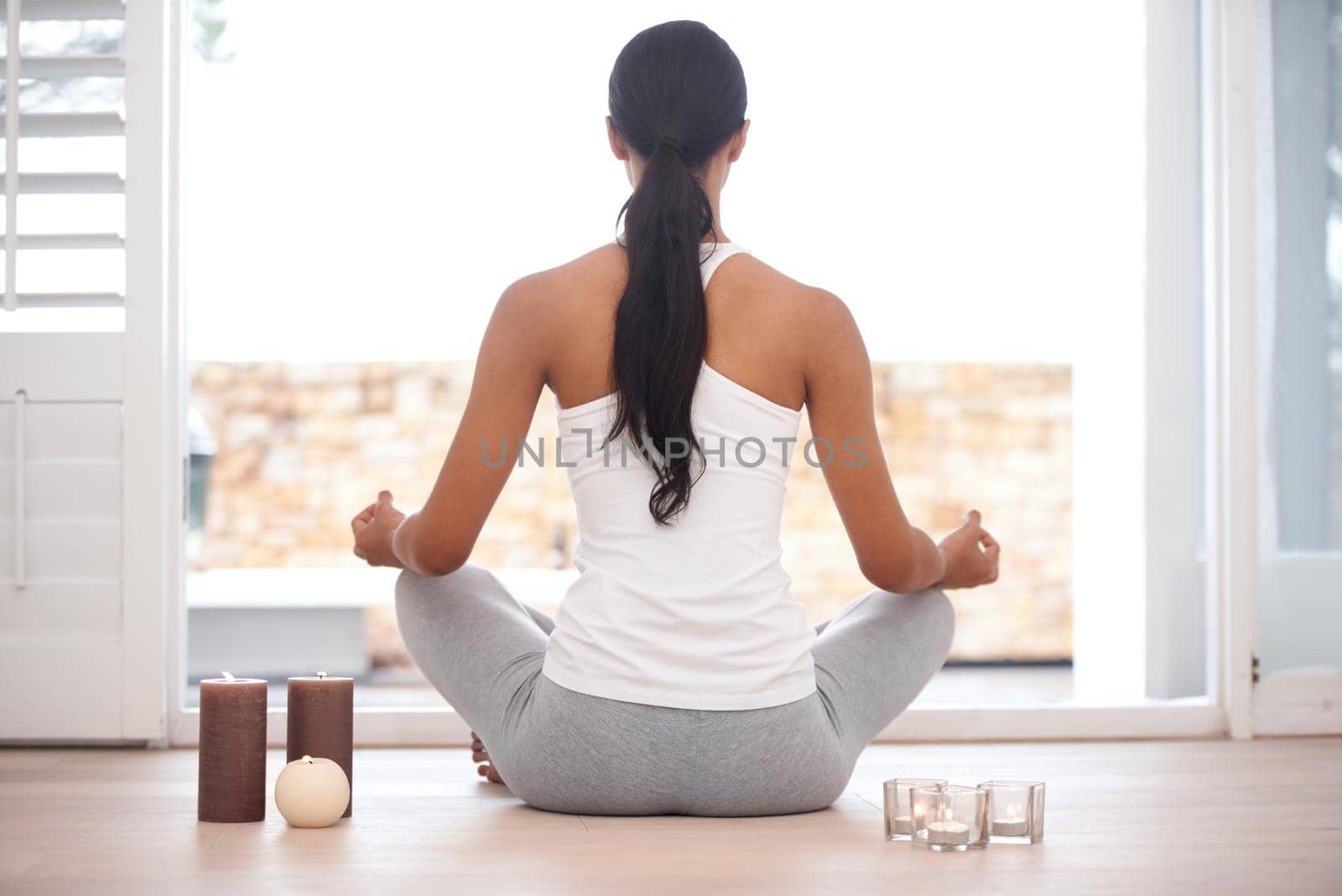 Rearview image of a woman meditating at home.