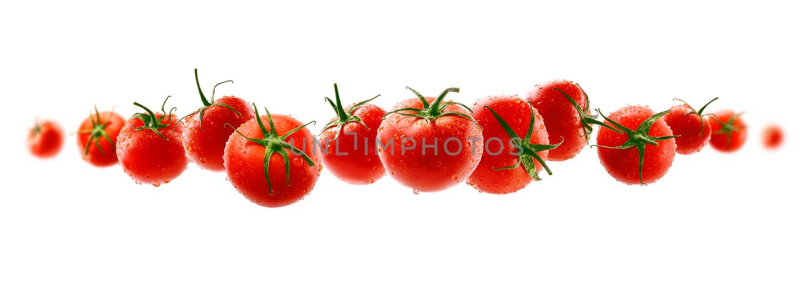 Red tomatoes levitate on a white background.