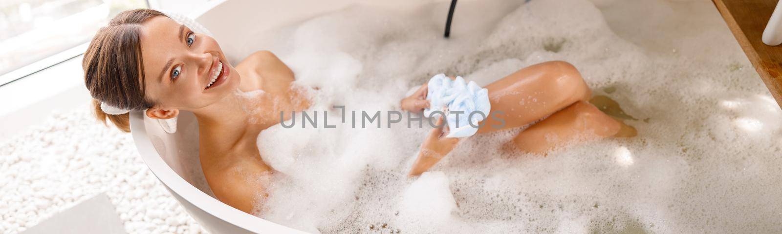 Beautiful young woman bathing with pleasure while spending time at luxury spa resort. Wellness, body care concept