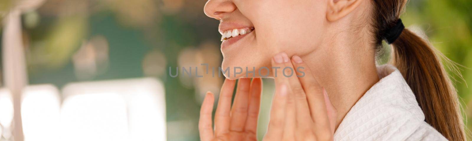 Closeup of young woman with beautiful smile and perfect skin enjoying beauty procedures, taking care of her skin by Yaroslav_astakhov