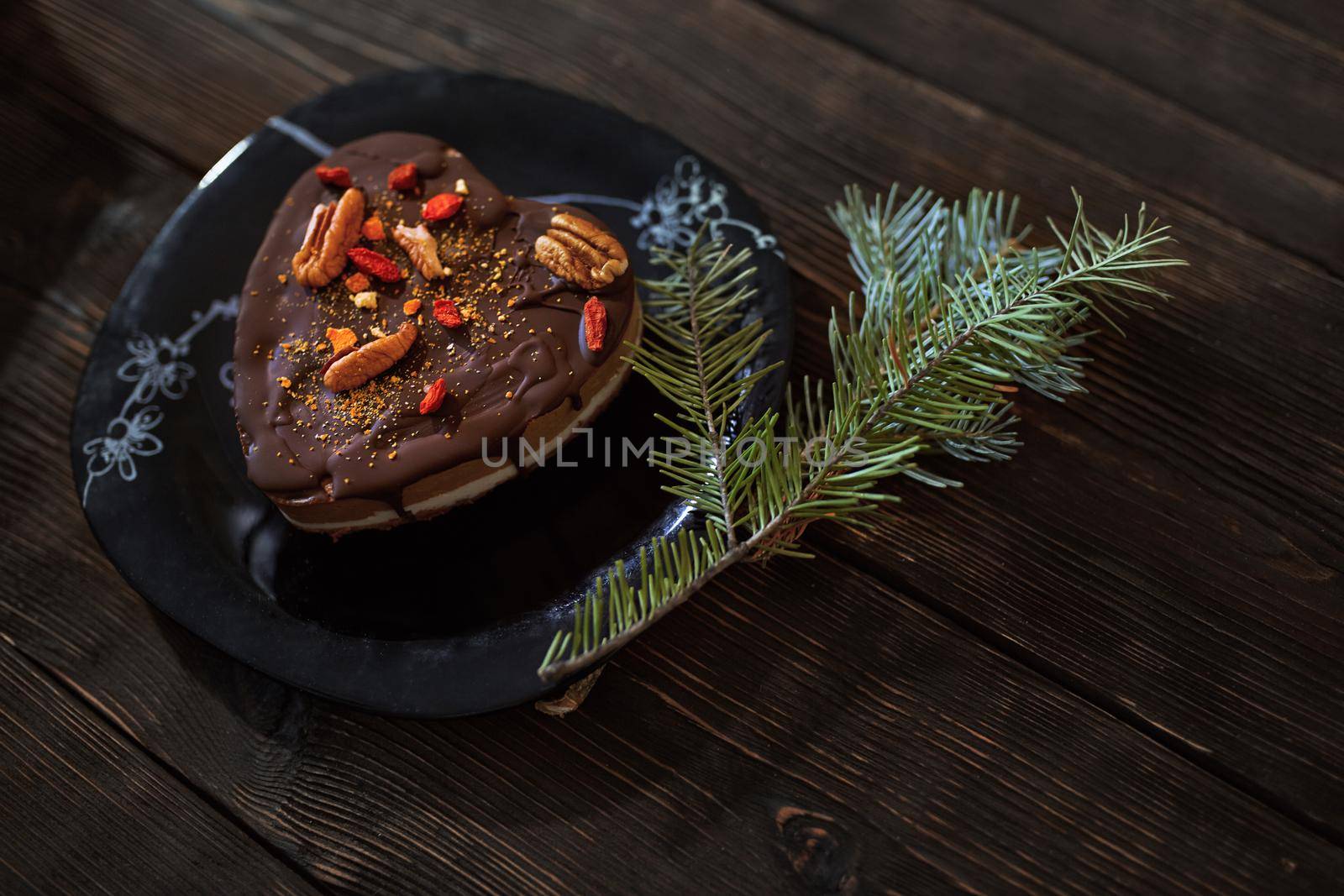 Gluten and dairy free chocolate cake with Christmas tree twig on a wooden table