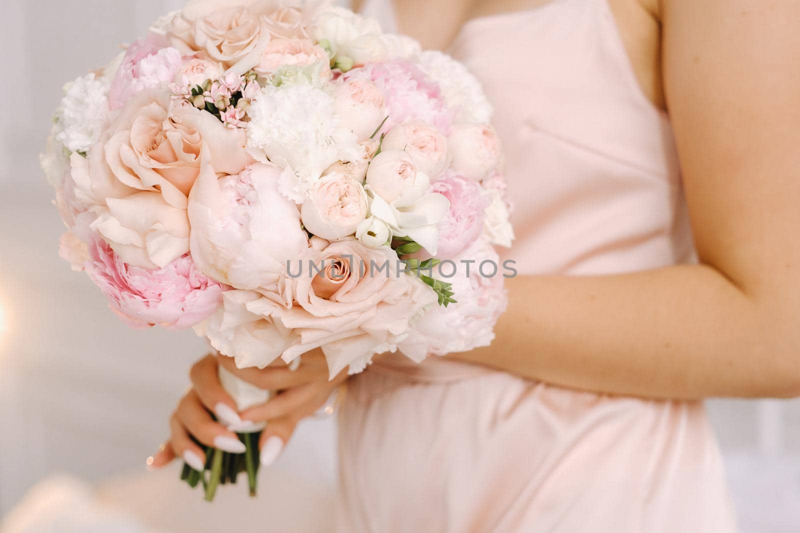 The bride holds a wedding bouquet of roses in her hands. Wedding floristry.