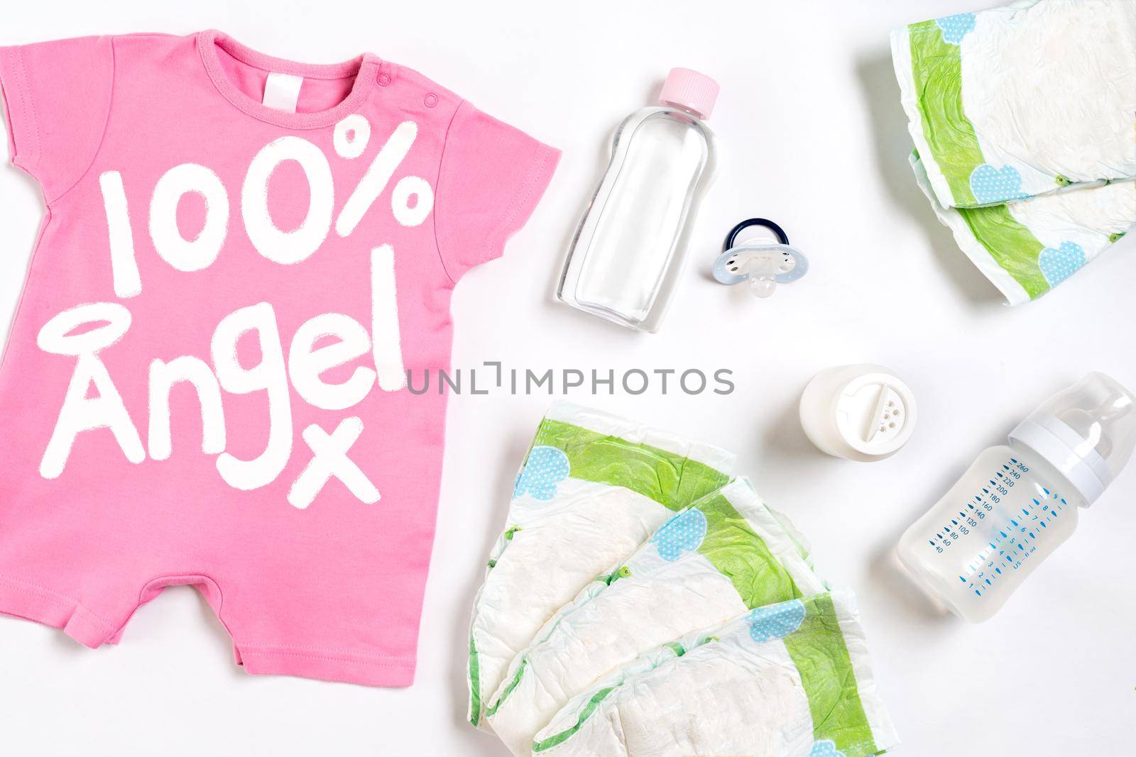 Babies goods diaper, baby powder, cream, shampoo, oil on white background with copy space. Top view or flat lay. Maternity concept