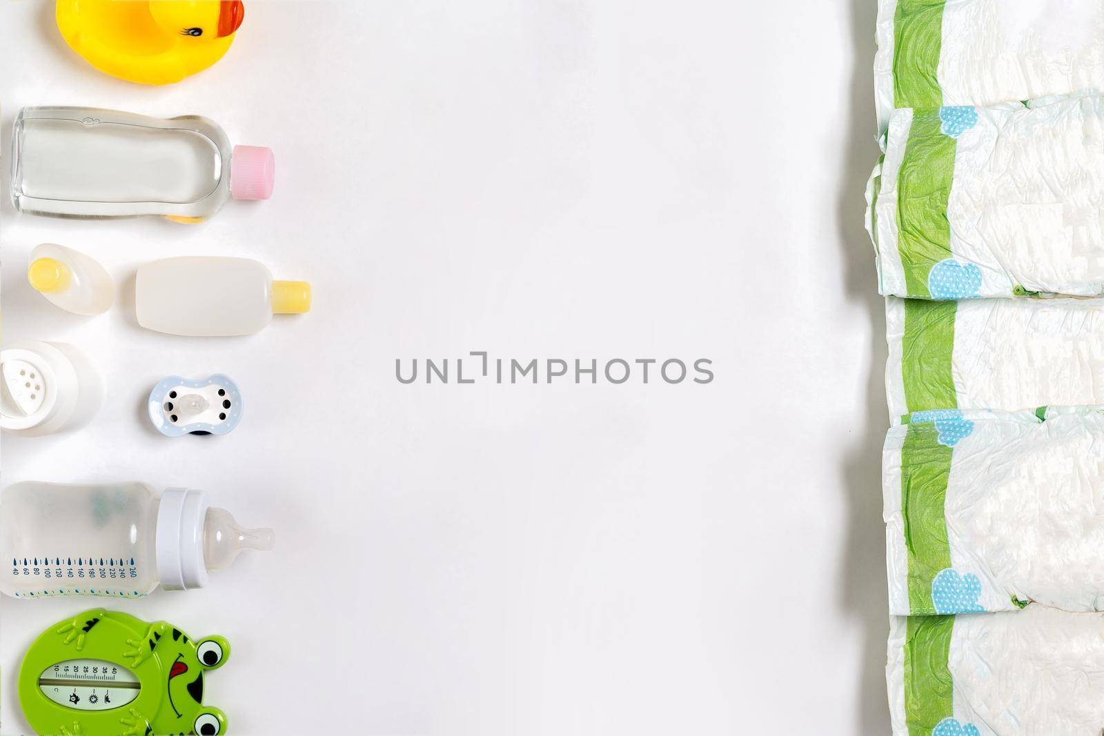 Babies goods diaper, baby powder, cream, shampoo, oil on white background with copy space. Top view or flat lay. by nazarovsergey