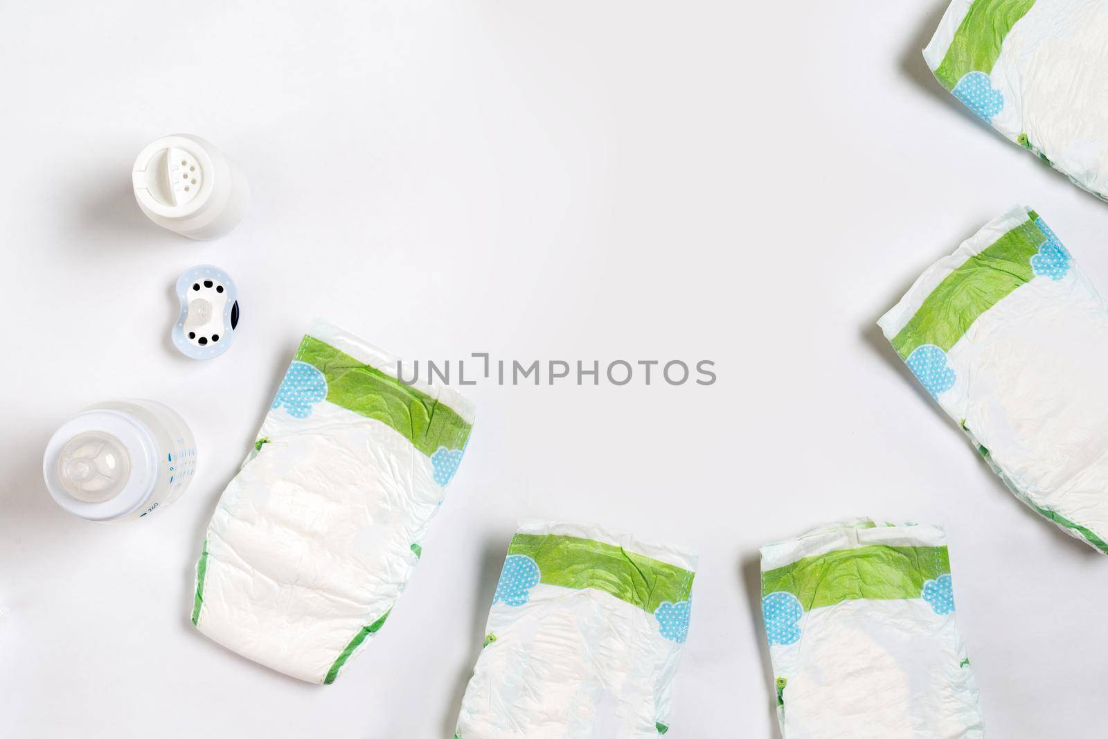 Babies goods diaper, baby powder, cream, shampoo, oil on white background with copy space. Top view or flat lay. by nazarovsergey