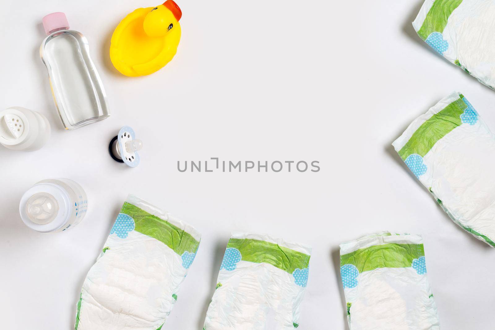 Babies goods diaper, baby powder, cream, shampoo, oil on white background with copy space. Top view or flat lay. by nazarovsergey