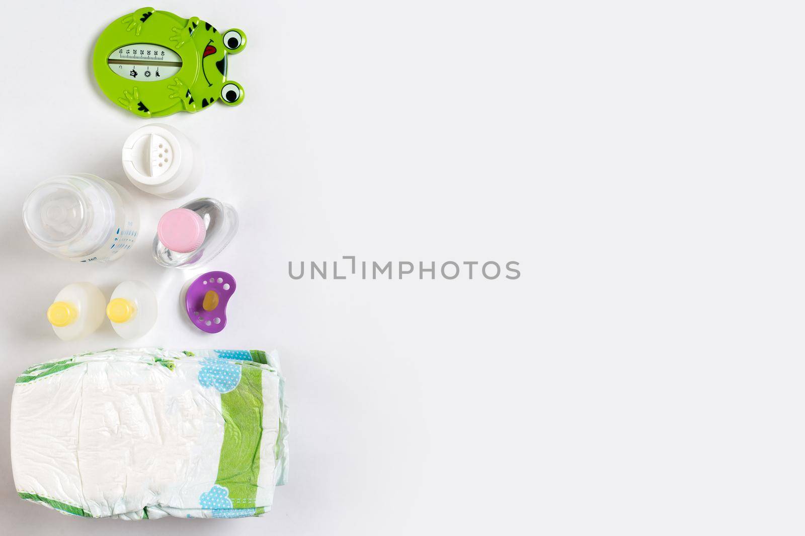 Babies goods diaper, baby powder, cream, shampoo, oil on white background with copy space. Top view or flat lay. by nazarovsergey
