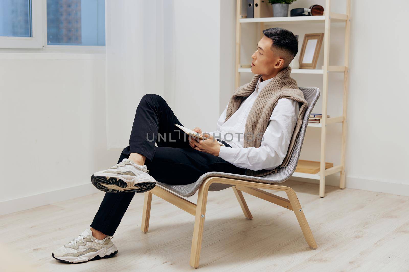 man with a tablet sits in a chair communication interior. High quality photo