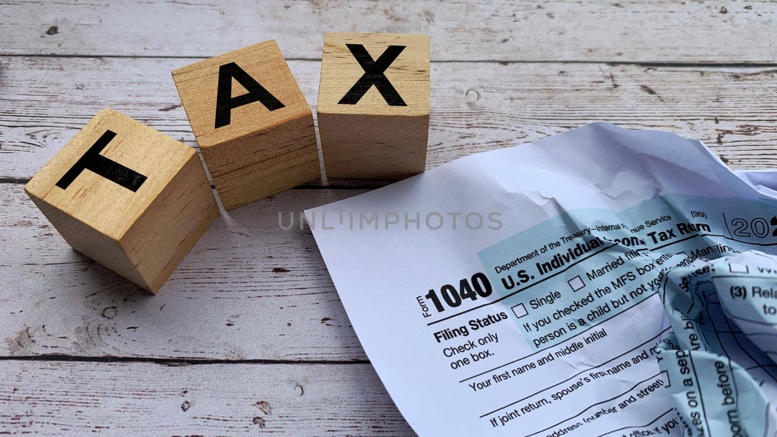 Tax labeled on wooden blocks with tax form background. Tax concept