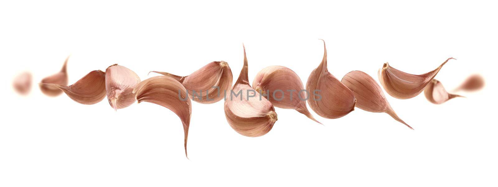 Garlic cloves levitate on a white background.