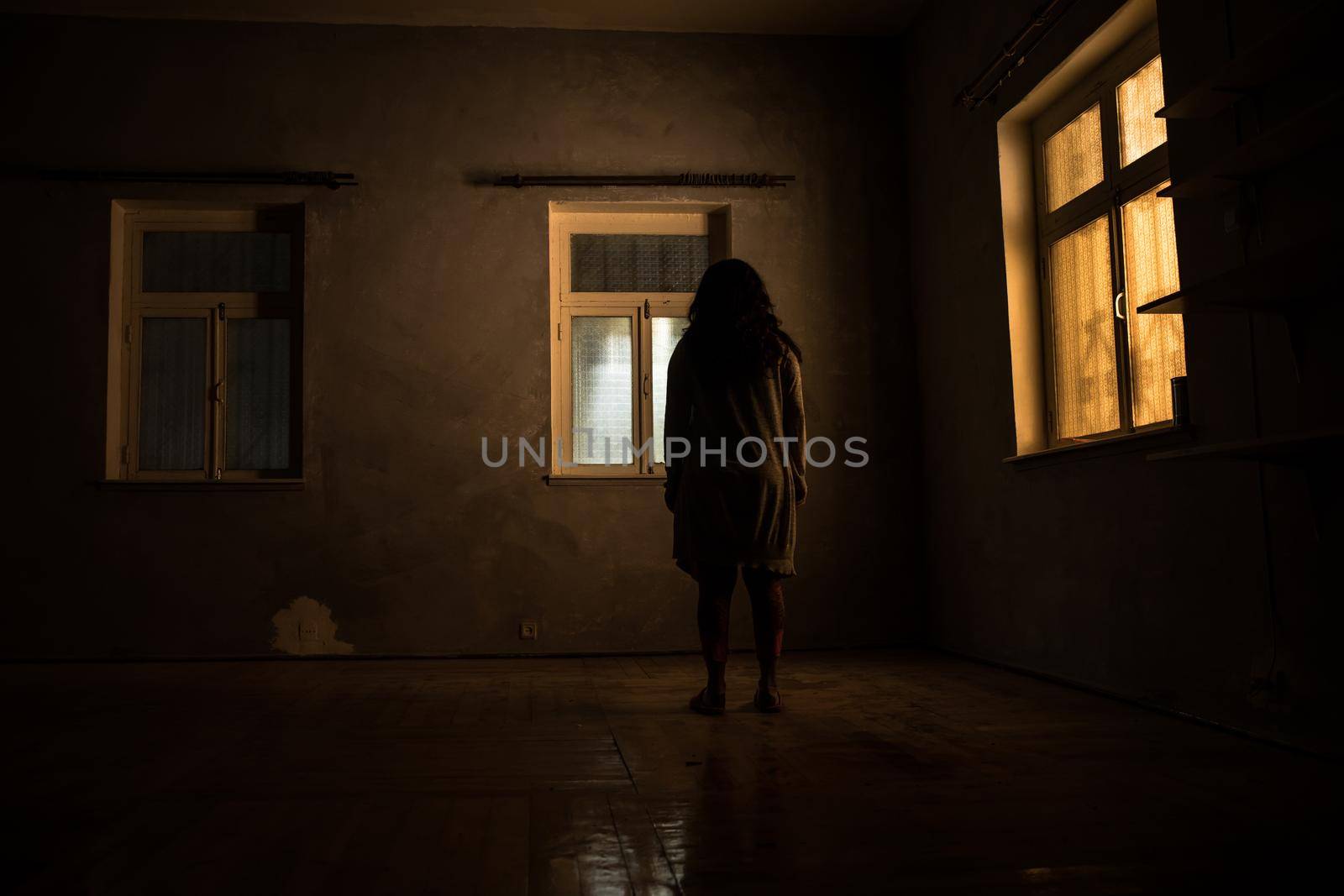 Horror silhouette inside abandoned creepy room with window at night. Horror scene. Halloween concept.