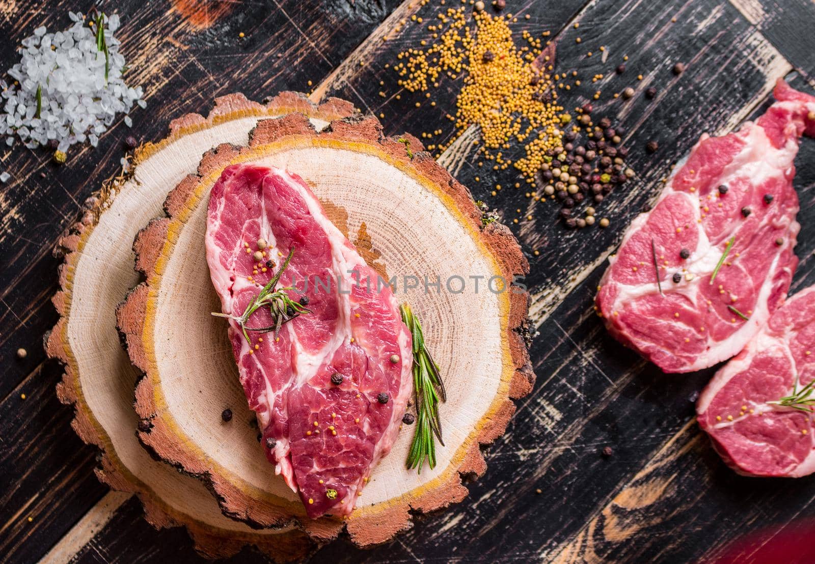 Raw juicy meat steak on dark wooden background ready to roasting by its_al_dente