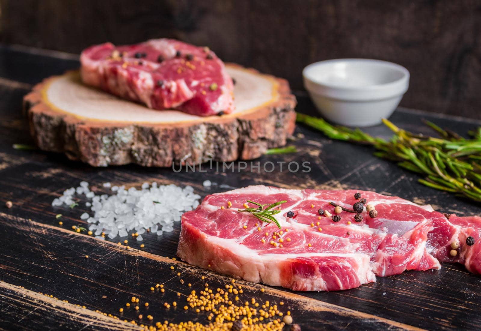 Raw meat steak on dark wooden background ready to roasting