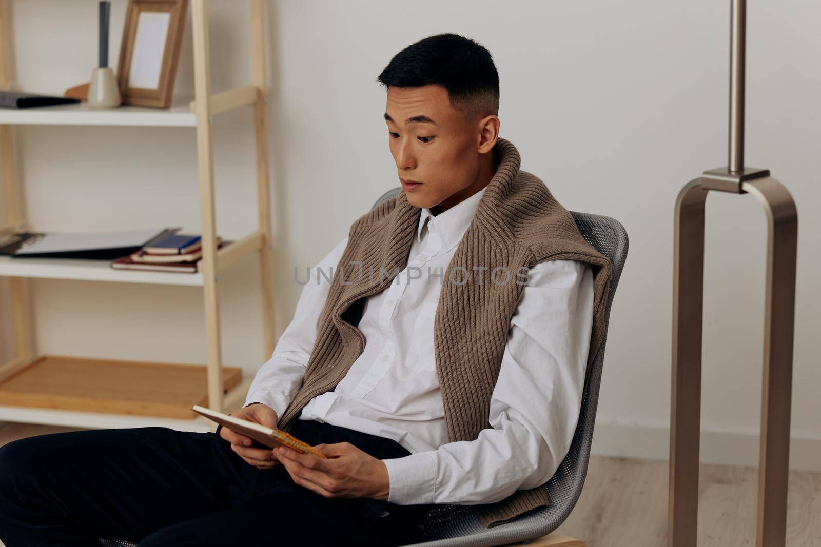 man with a tablet sits in a chair communication technologies by SHOTPRIME