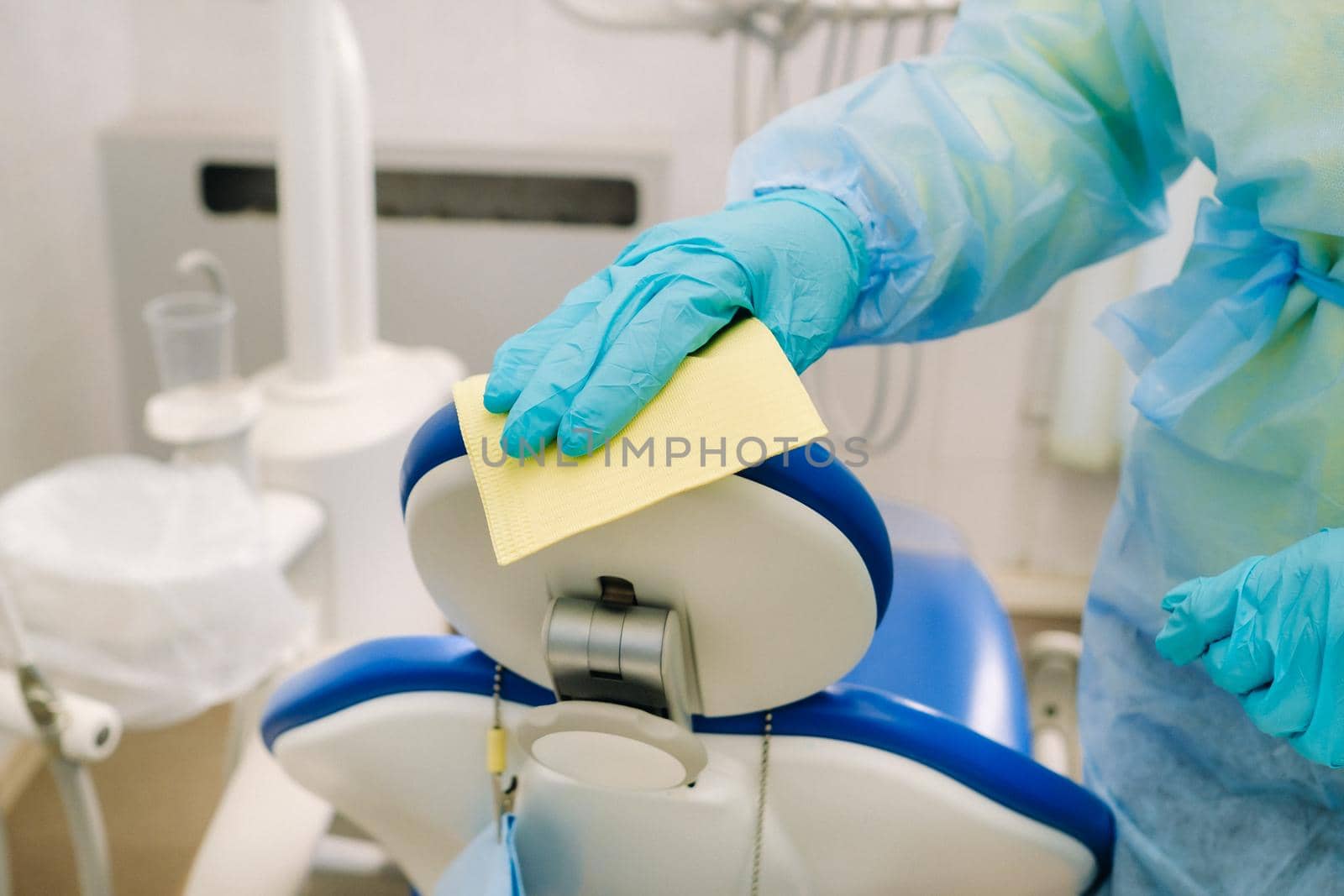 A nurse disinfects work surfaces in the dentist's office..