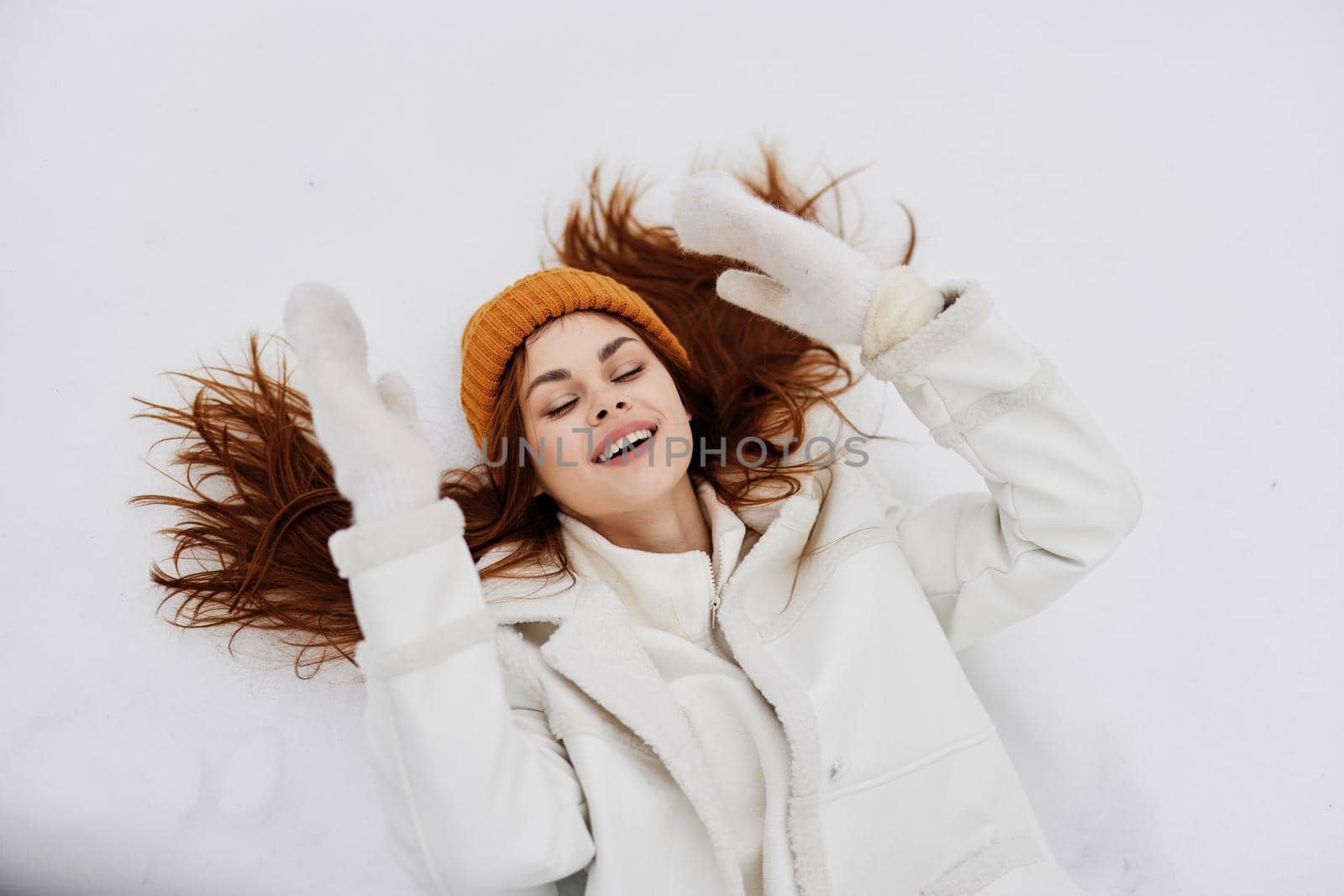Happy young woman lies on the snow fun rest nature fresh air. High quality photo