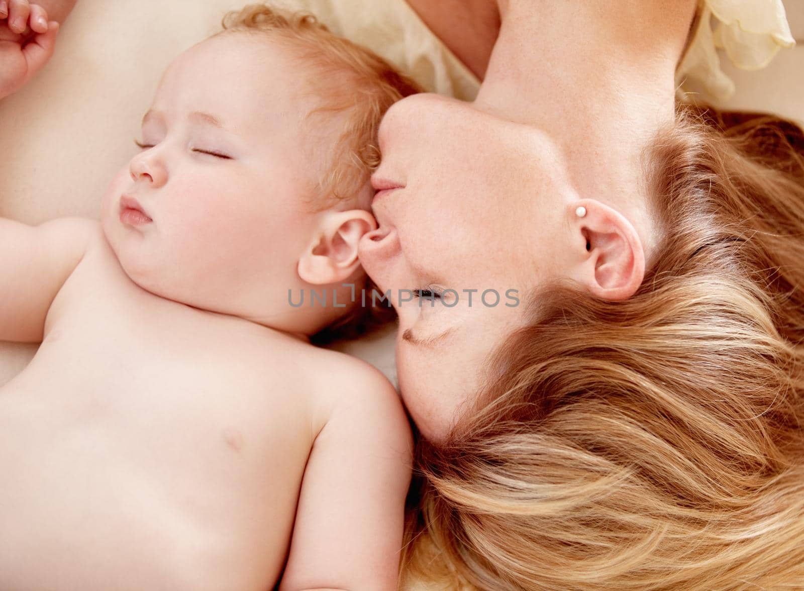 No closer bond than a mother and her child. Tiny baby boy lying fast asleep alongside his mother. by YuriArcurs