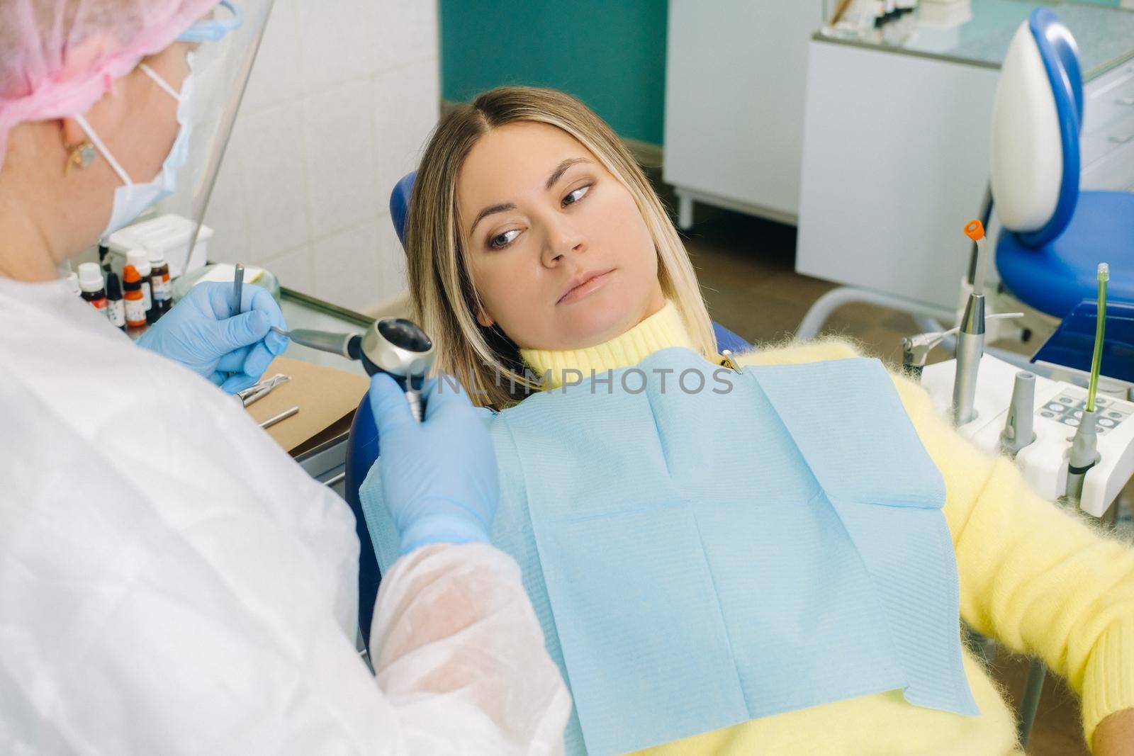 The girl is sitting in a dentist's chair before treatment and is afraid.