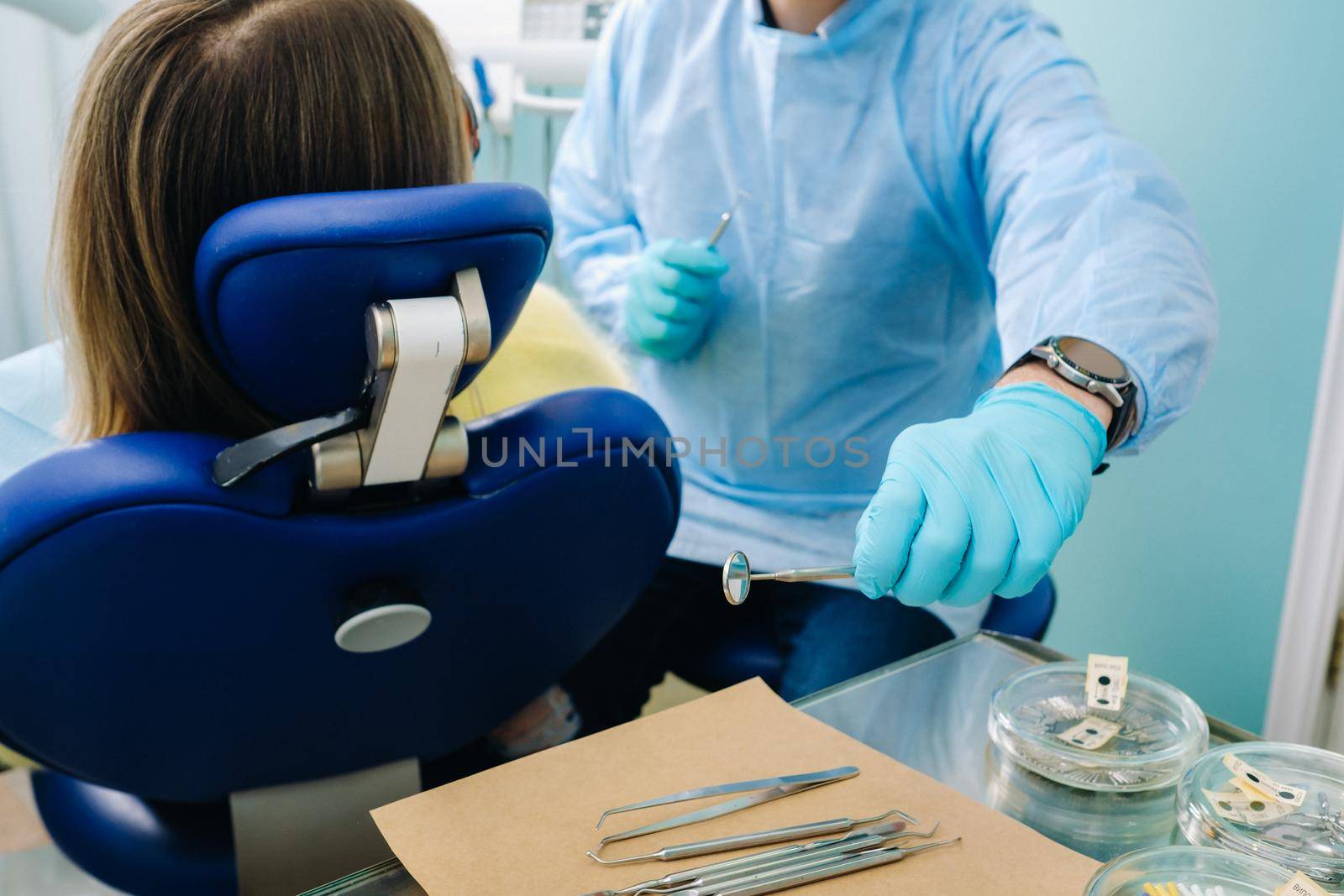 The dentist takes the tools to treat the patient's teeth.