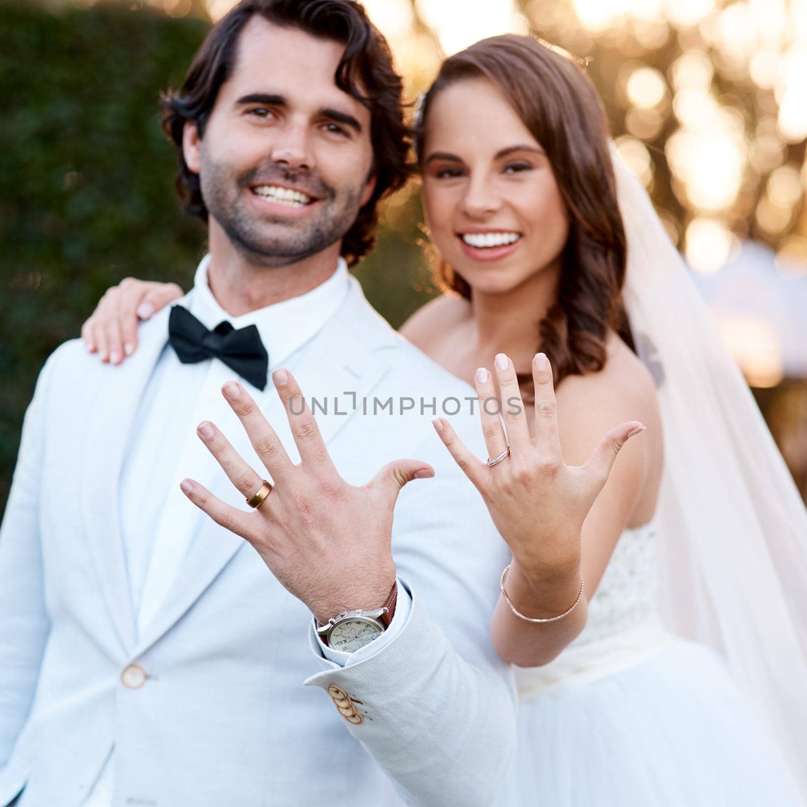 We just got married. Cropped shot of a newlywed couple showing off their wedding rings. by YuriArcurs